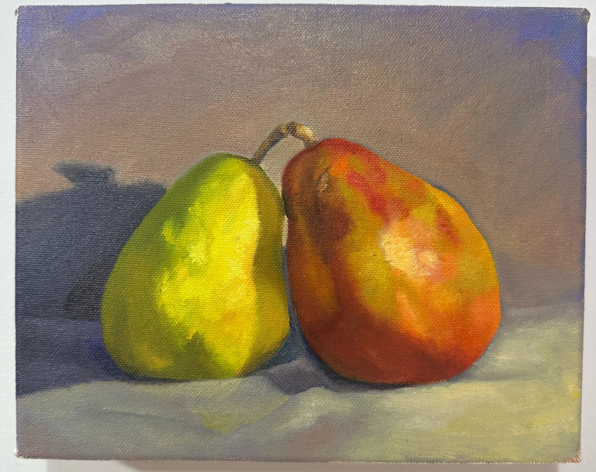 Original 8 by 10 inch oil painting titled Insepearable by Kael Von, depicting two pears — one green and one red-gold — leaning against each other on a soft purple background