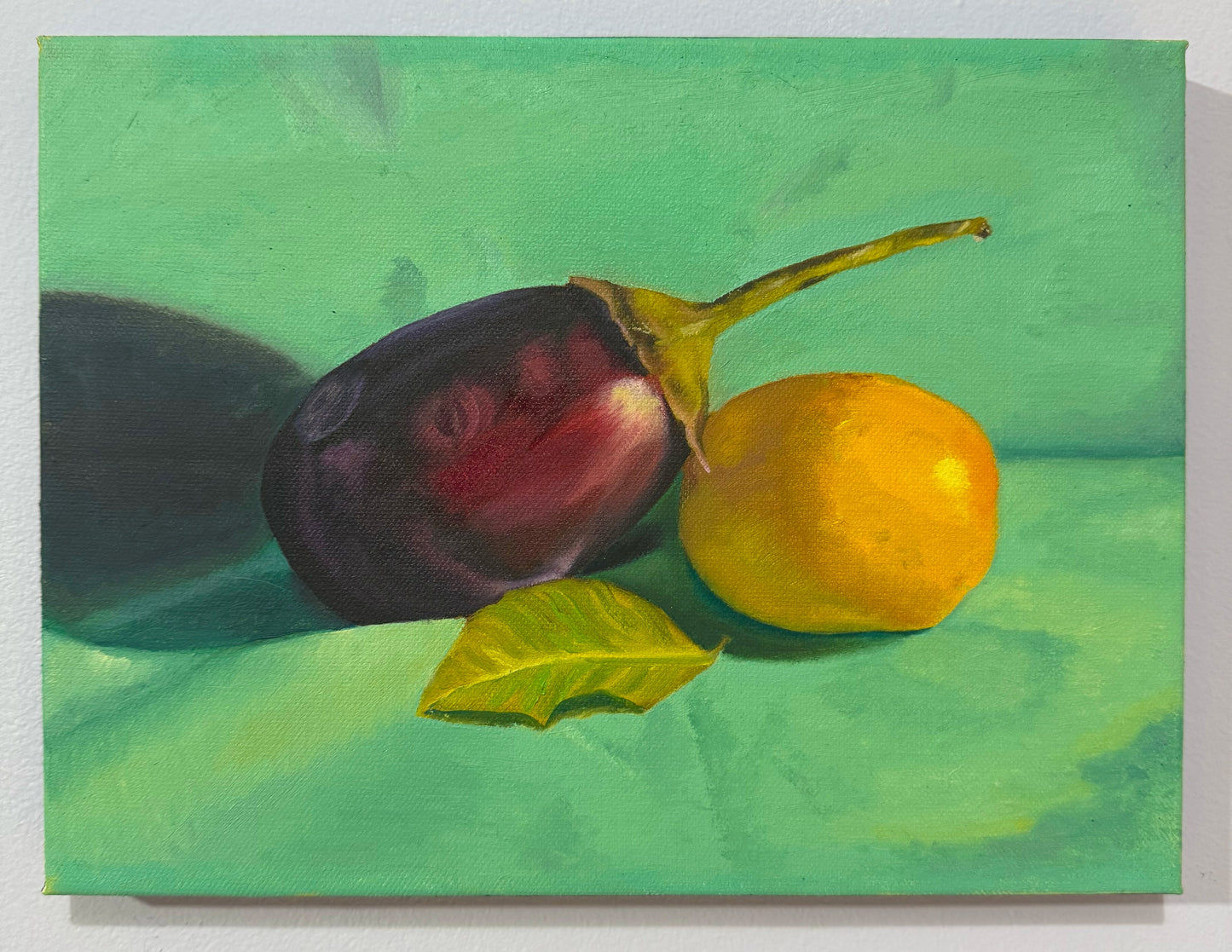 Original 9 by 12 inch oil painting titled Unlikely Best Friends by Kael Von, depicting a deep purple eggplant, a bright yellow lemon, and a green leaf in still life