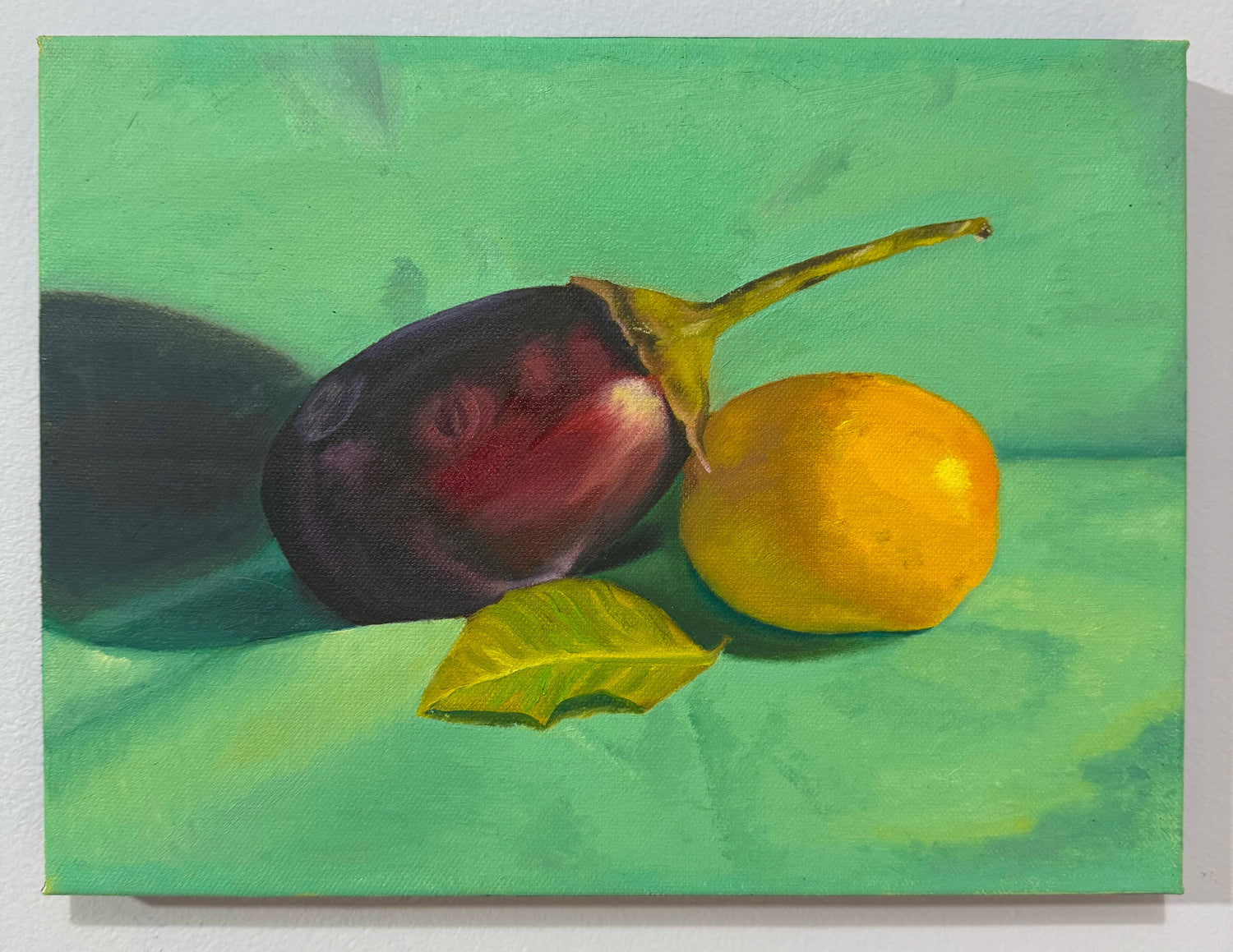 Original 9 by 12 inch oil painting titled Unlikely Best Friends by Kael Von, depicting a deep purple eggplant, a bright yellow lemon, and a green leaf in still life