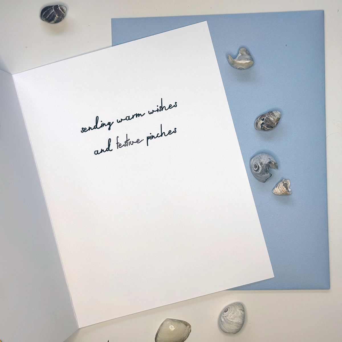 Inside of Crabby Holidays Christmas card reading sending warm wishes and festive pinches