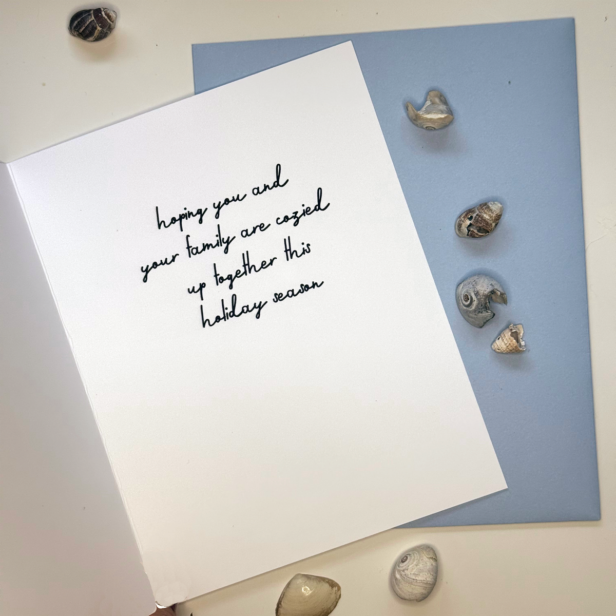 Inside of Once Upon a Fish-Mas sardine Christmas card reading hoping you and your family are cozied up together this holiday season